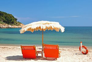 Strandliegen und Sonnenschirm am Strand der Fetovaia-Bucht