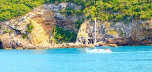 Küste der Insel Giglio mit kleinem Segelschiff